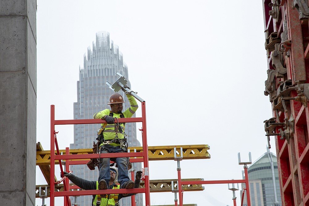 Construction worker in Charlotte, putting up scaffolding.