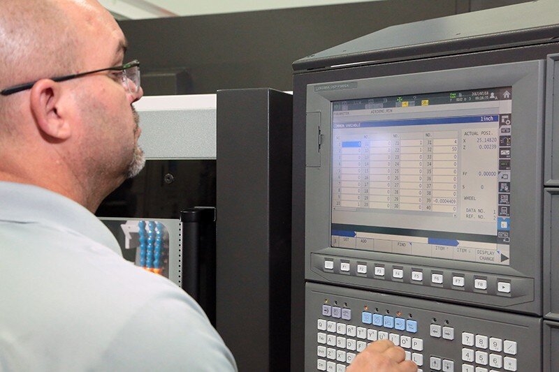 Operator programming CNC machine in Charlotte.