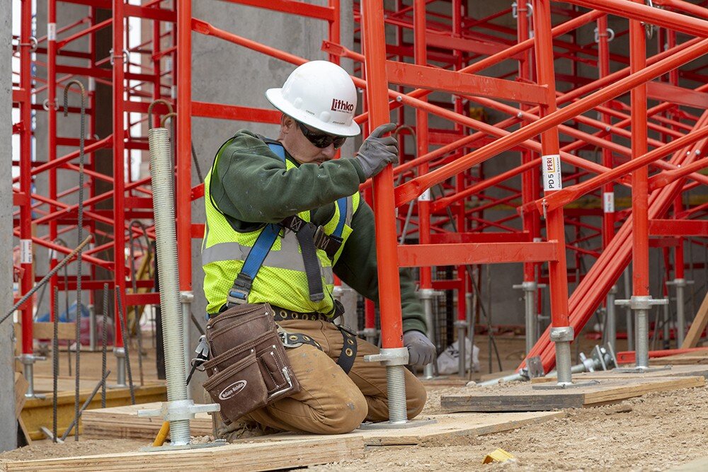 Man raising legs on red scaffolding.