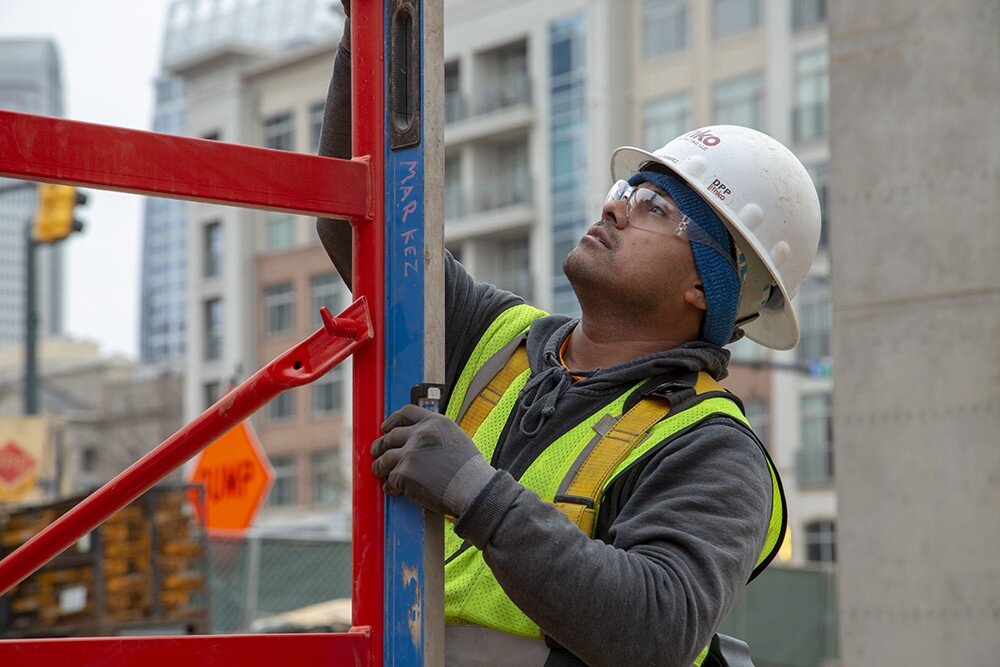 Man leveling red scaffolding.
