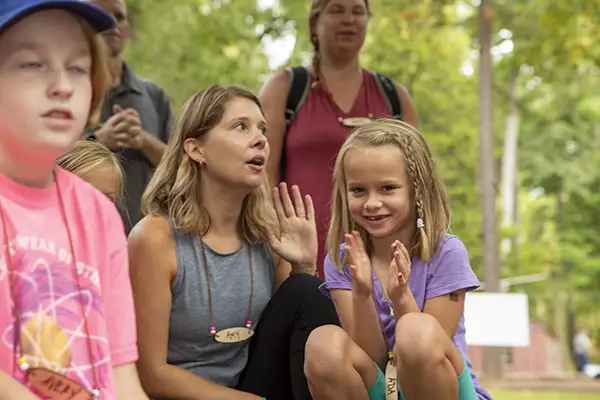 Young girl clapping to camp singing.