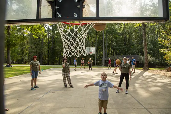 Boy make perfect shoot, playing basketball at camp.