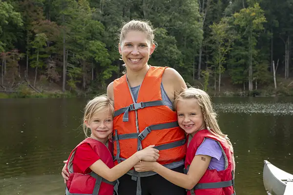 Mom and two daughters at lake during camp.