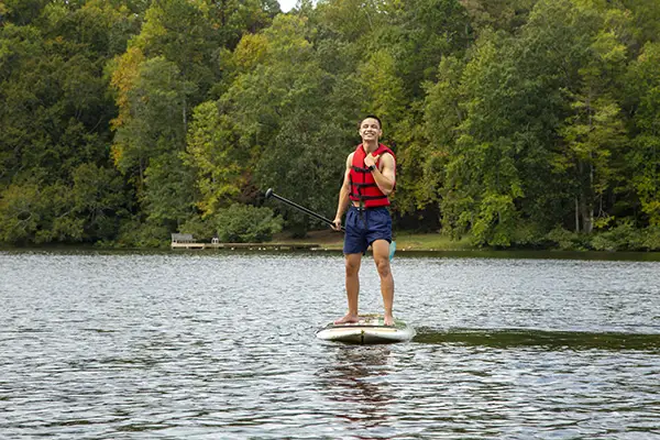 Guy on paddle board smiling for the camera.