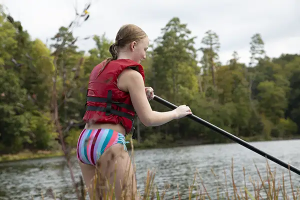 Girl on lake paddleboarding.